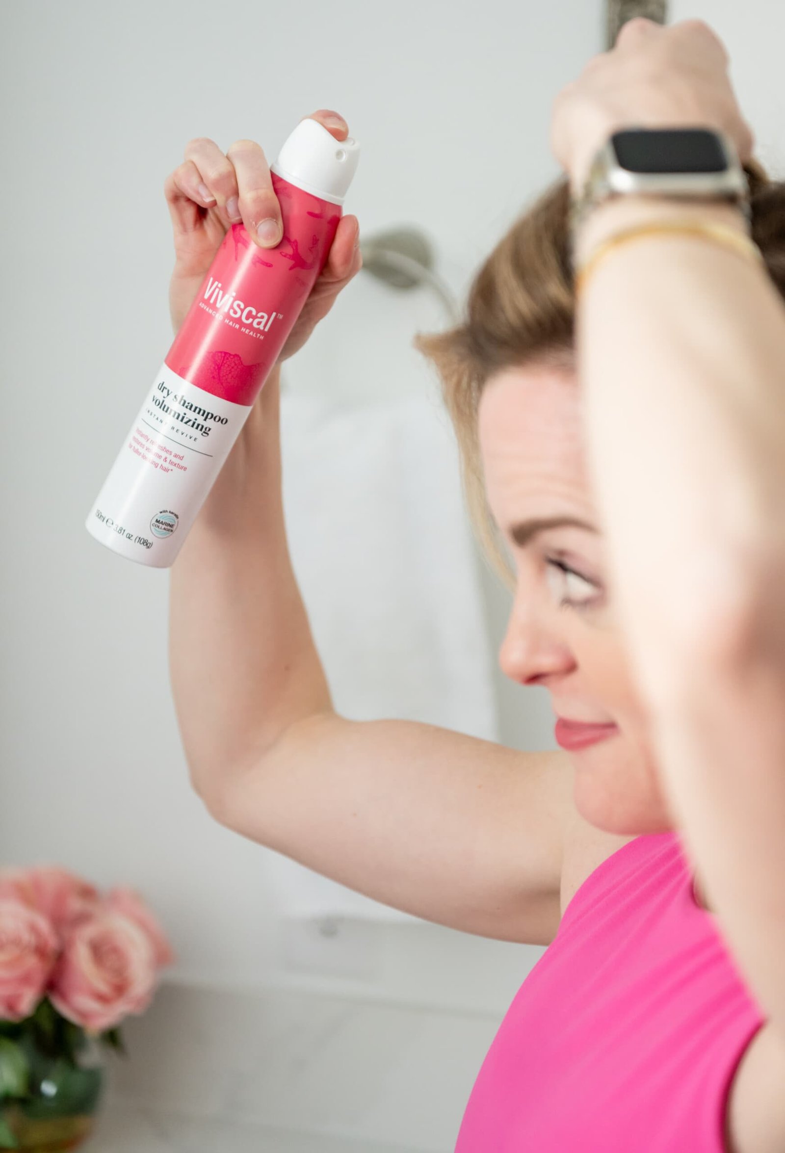 Mulher aplicando shampoo seco Viviscal no cabelo e couro cabeludo