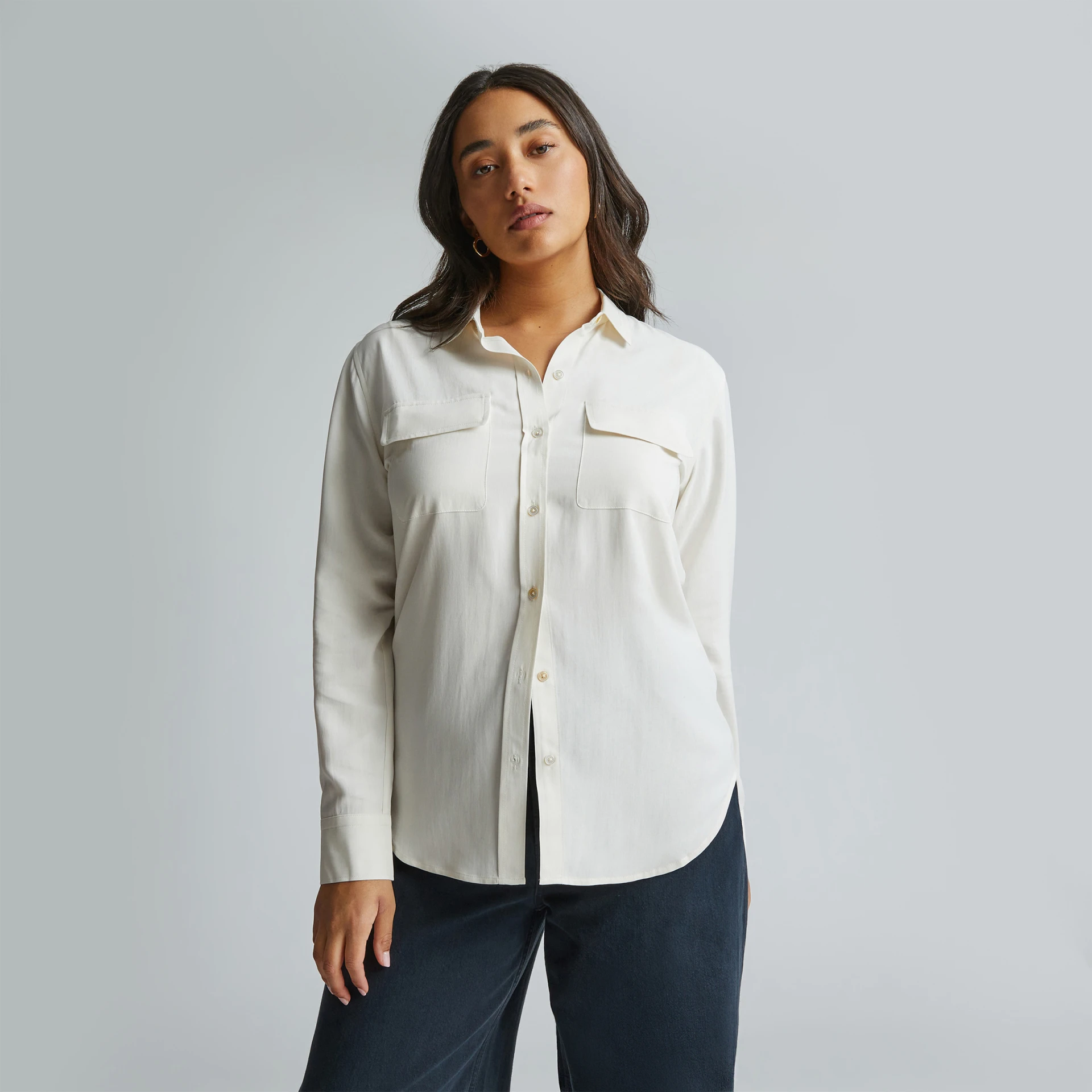 Mulher com camisa branca de manga comprida com botões 
