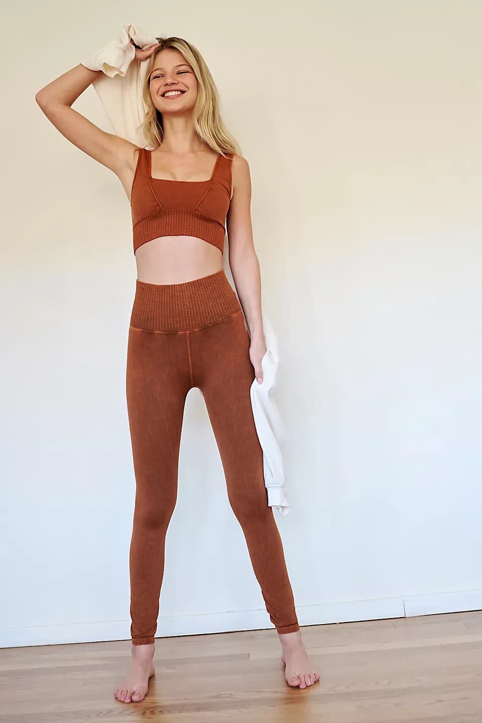 Mulher com legging laranja queimada e top combinando 