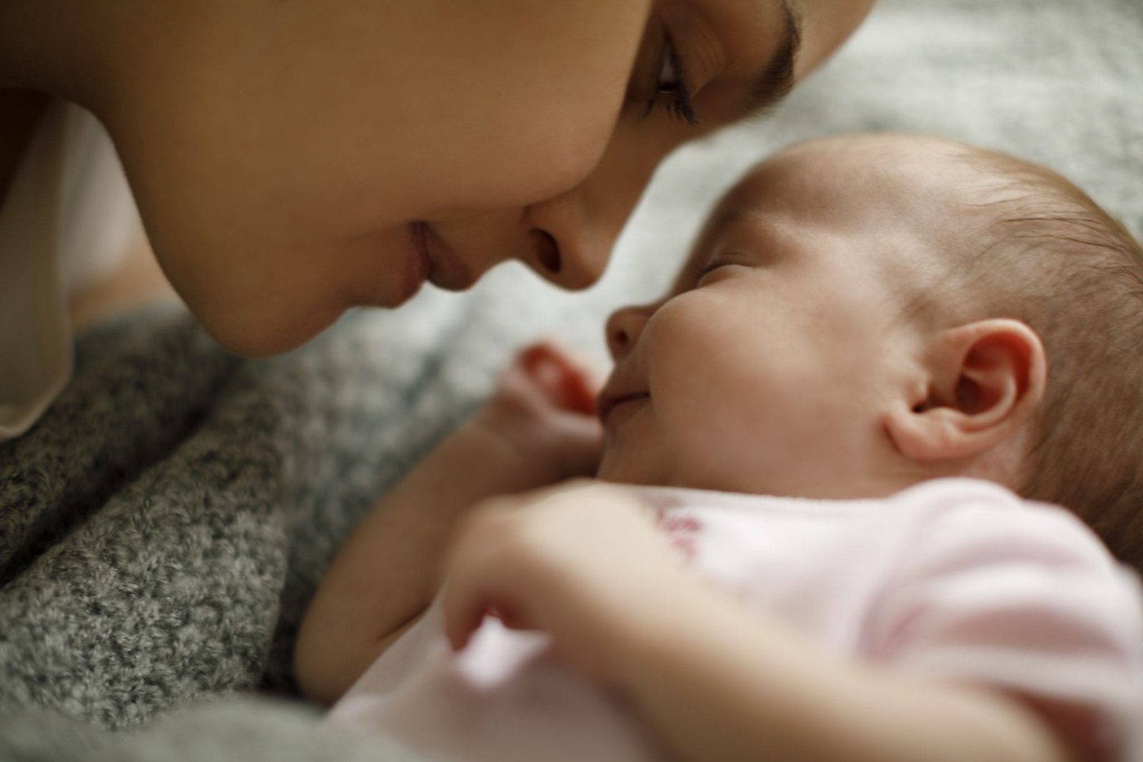 Mother and baby playing in the bed and smiling.