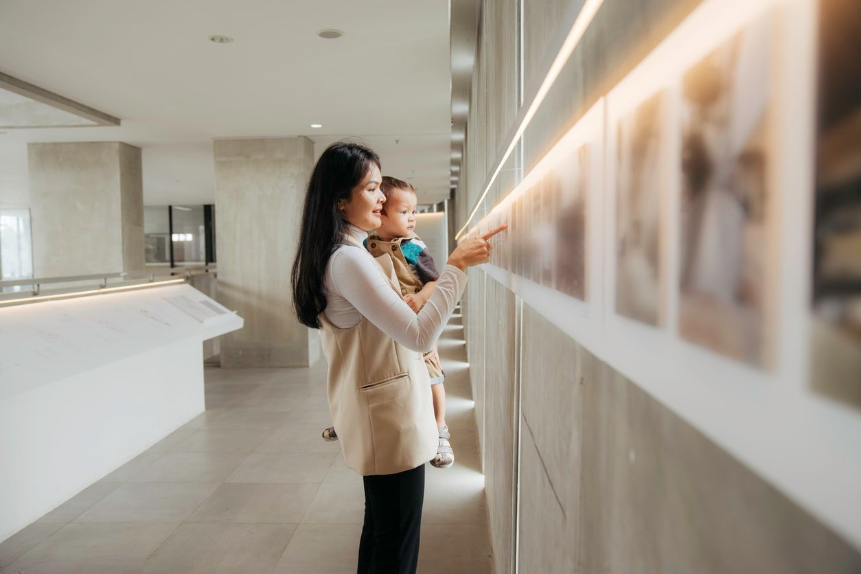 Mulheres asiáticas assistindo a exposição com seu bebê na galeria de arte