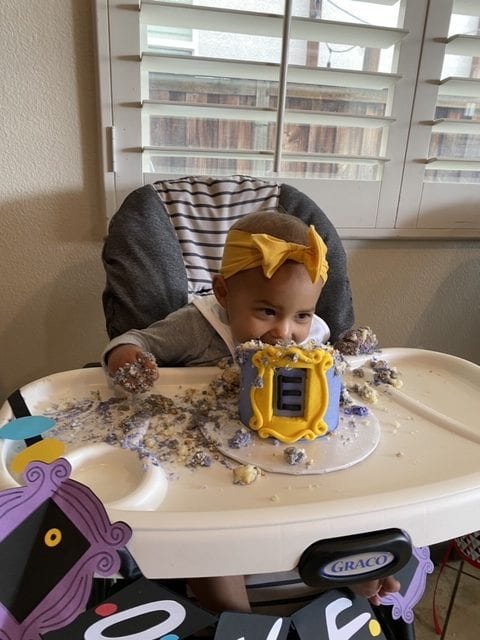 Menina comendo o bolo smash dos amigos