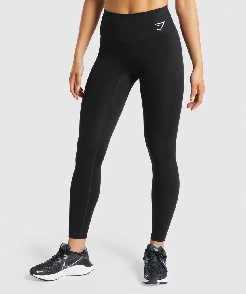 Mulher de legging preta e tênis preto 