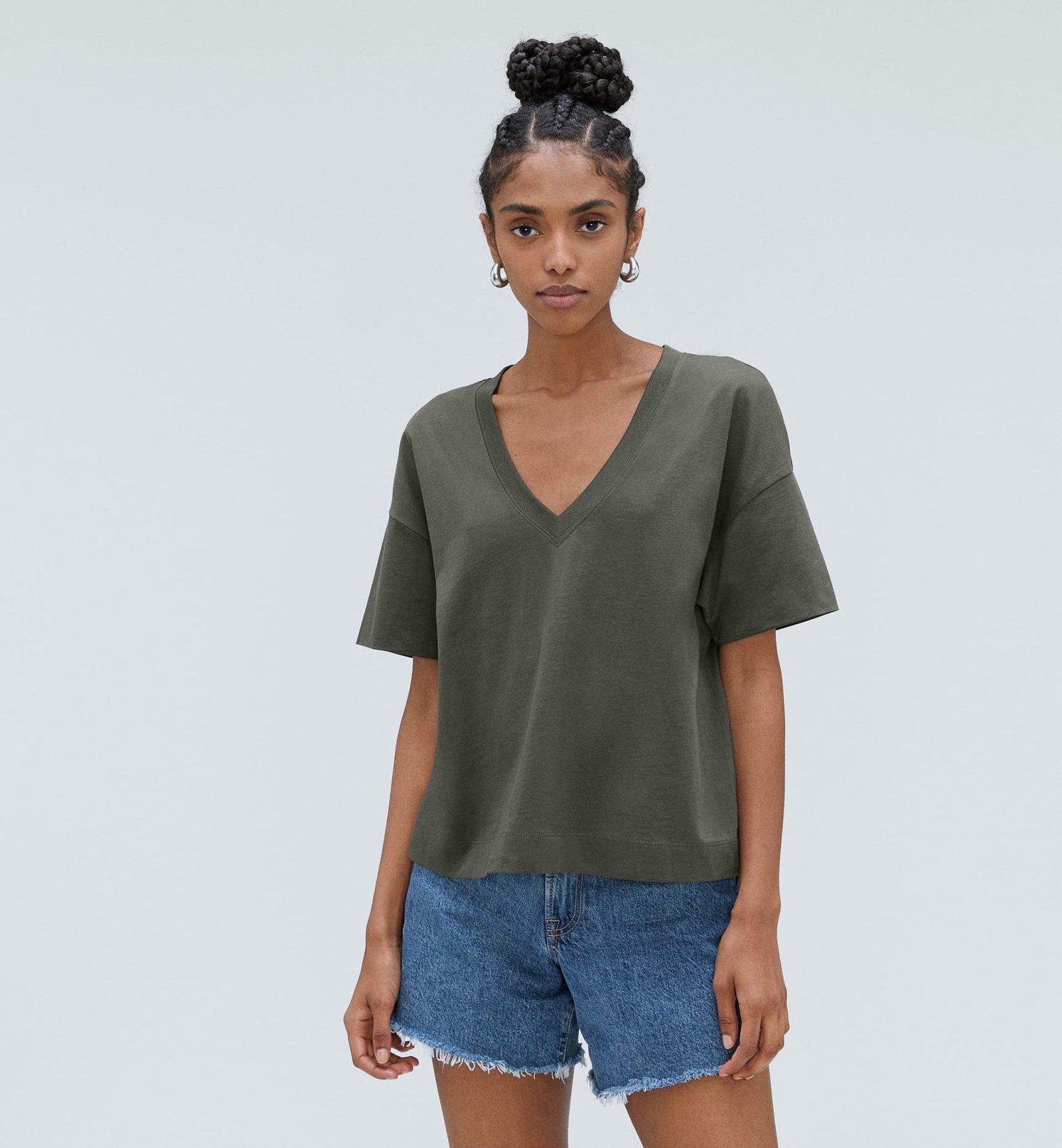 Mulher de camisa com decote em V e shorts jeans
