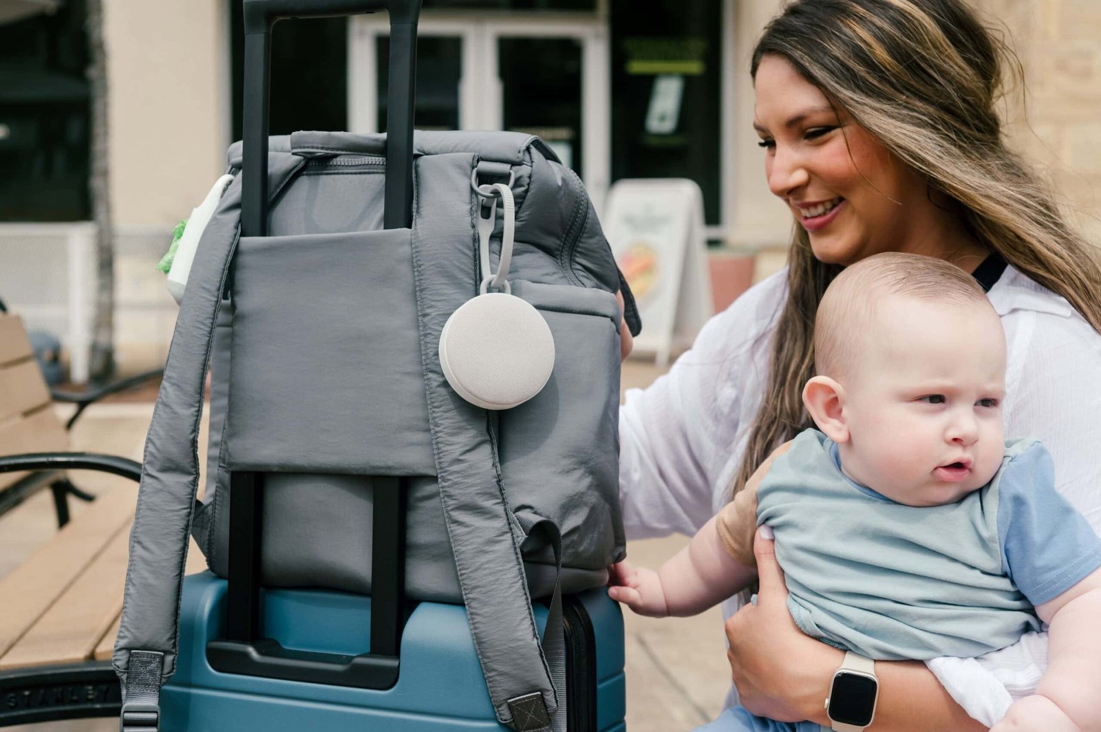 Mãe e bebê ao lado de uma bolsa CALPAK em uma mala