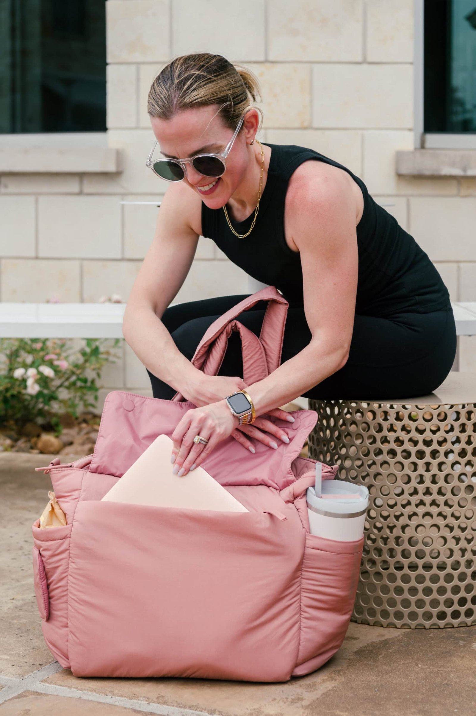 Mulher tirando seu laptop da bolsa de fraldas CALPAK 